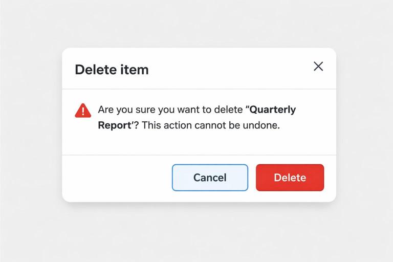 Accessible confirmation modal mockup for deleting an item: title Delete item, warning text naming Quarterly Report and stating it cannot be undone, Cancel button focused by default, and a visually distinct red Delete button. Clean UI, high contrast, clear hierarchy.